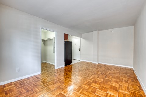 an empty living room with wood flooring and white walls